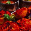Charred tandoori momos with coriander and chutneys in copper bowls